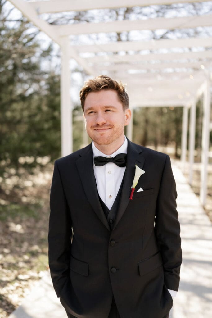 Portrait of the groom under the pergola hallway at Soli Deo Gloria Weddings and Events in Decatur