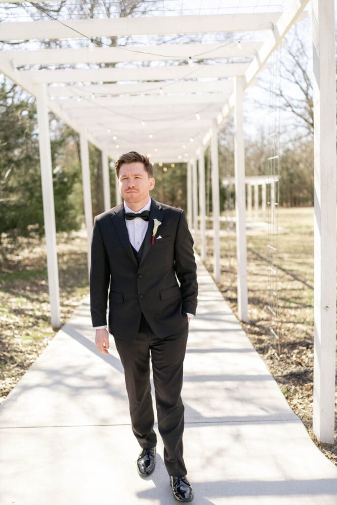 Portrait of the groom under the pergola hallway at Soli Deo Gloria Weddings and Events in Decatur