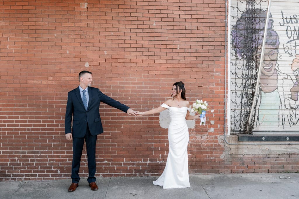Bride and groom posing for photos outside of Soma Winery in Fort Worth, TX