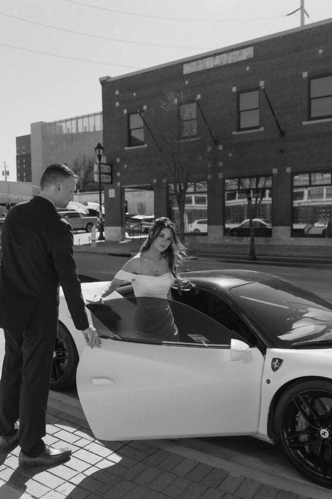Groom holding the door of his Lamborghini open for his bride