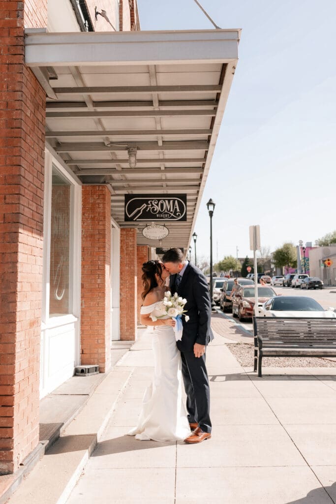 Bride and groom posing for photos outside of Soma Winery in Fort Worth, TX