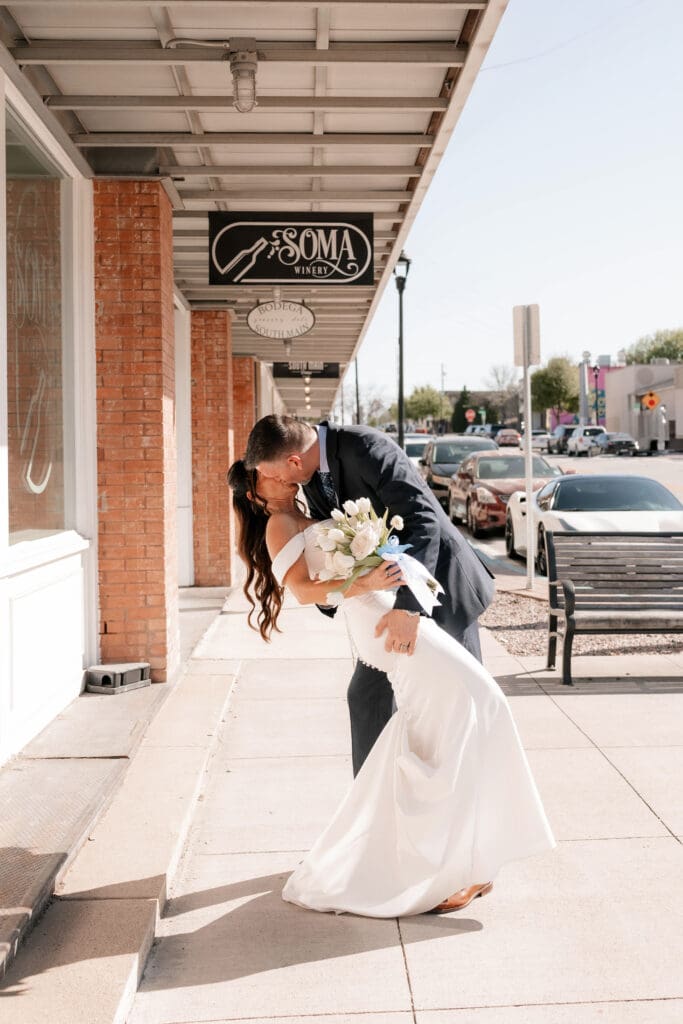 Bride and groom posing for photos outside of Soma Winery in Fort Worth, TX