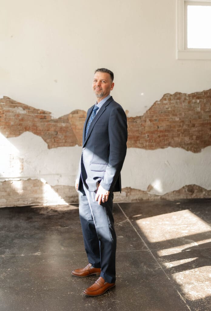 groom posing for photos inside Soma Winery in Fort Worth, TX
