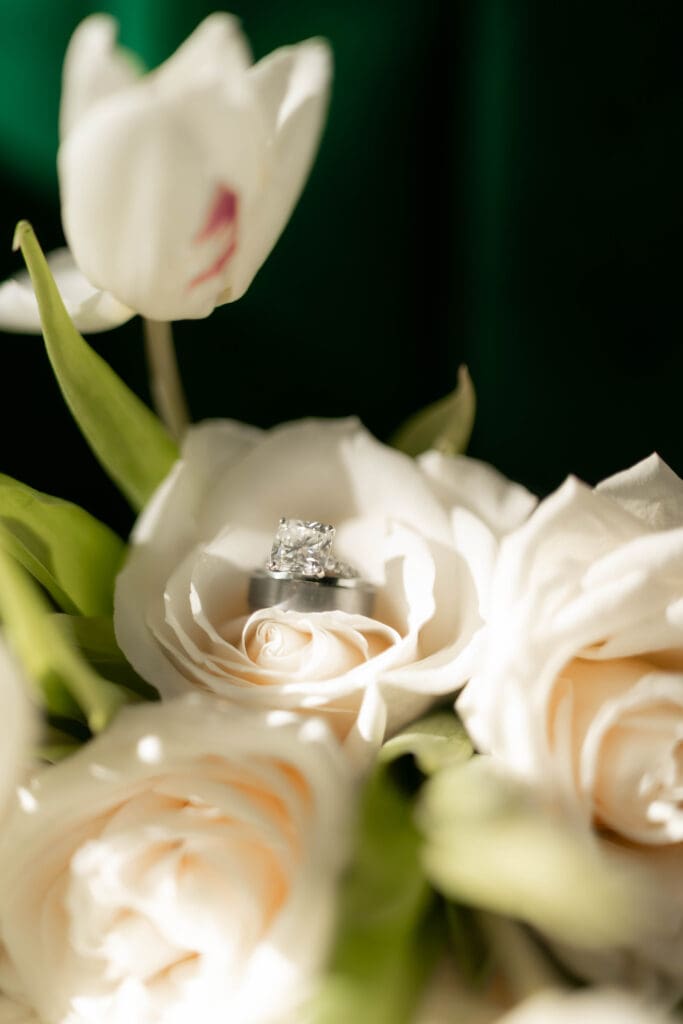 Close up shot of bride and groom's wedding rings in the bride's flower bouquet 