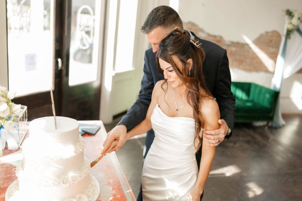 Bride and groom cutting their wedding cake at Soma Winery in Fort Worth, TX