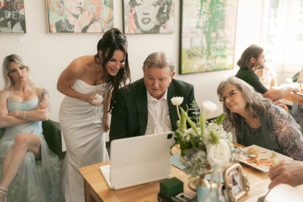 Bride watching the basketball game with her father and sister during her wedding reception