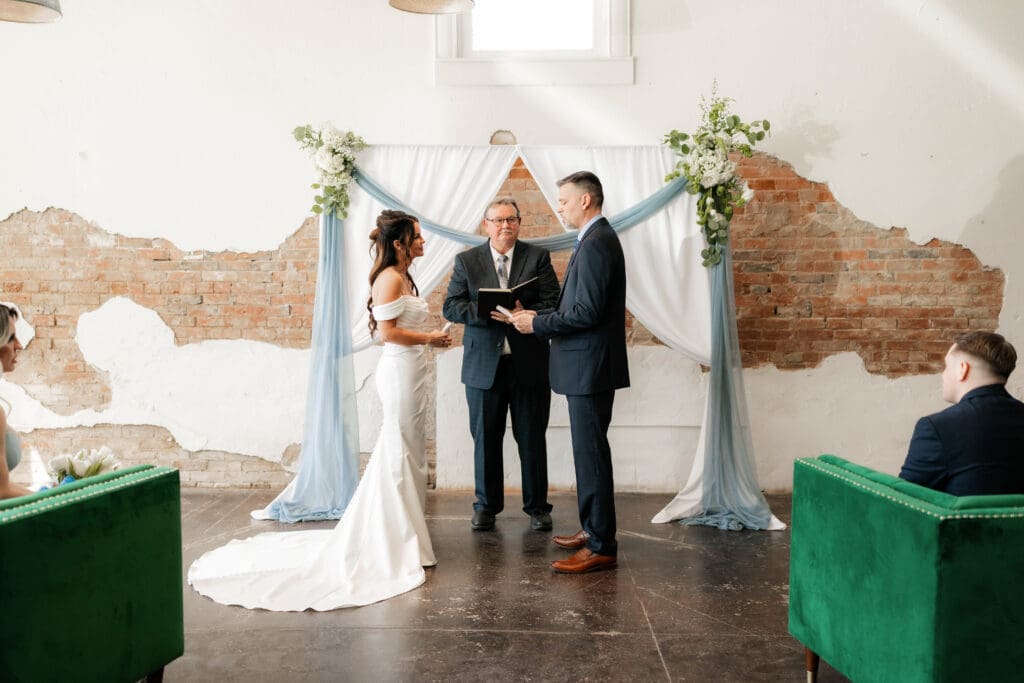 Bride and groom at altar during wedding ceremony at Soma Winery in Fort Worth, TX