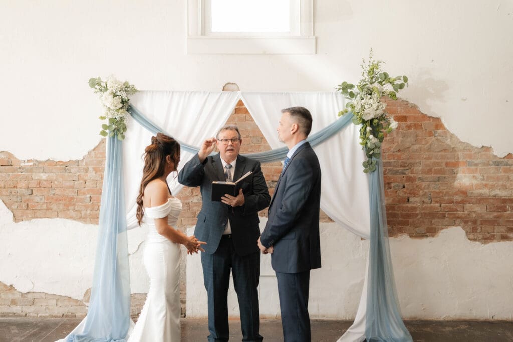 Bride and groom at altar during wedding ceremony at Soma Winery in Fort Worth, TX