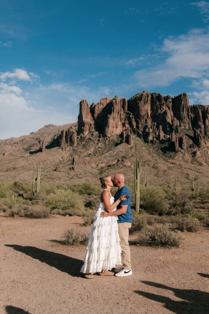 Bride and groom kissing amongst the desert landscape at Lost Dutchman State Park in Arizona