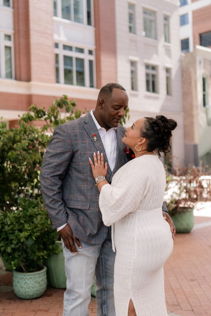 Man and woman posing during their engagement session at Sundance Square in Fort Worth, TX