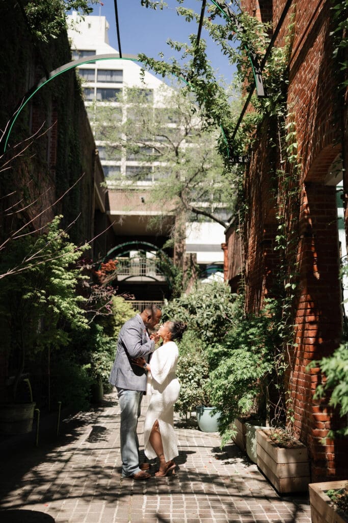 Man and woman posing during their engagement session in downtown in Fort Worth, TX