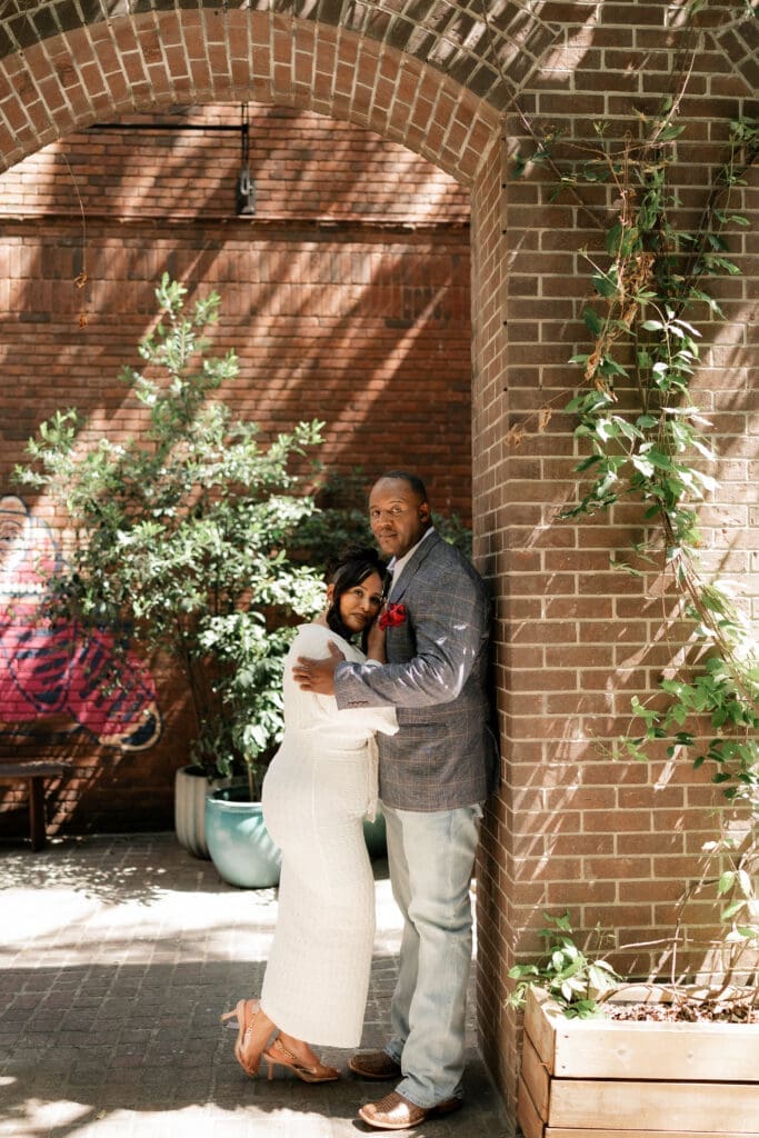 Moody portraits of a man and woman posing during their engagement session in downtown in Fort Worth, TX