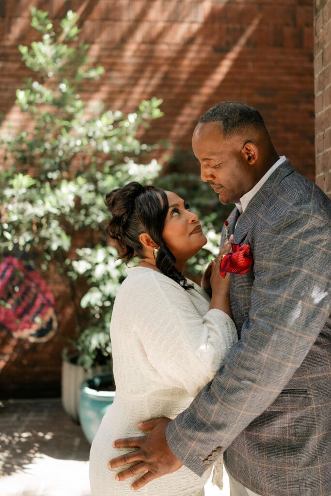 Moody portraits of a man and woman posing during their engagement session in downtown in Fort Worth, TX