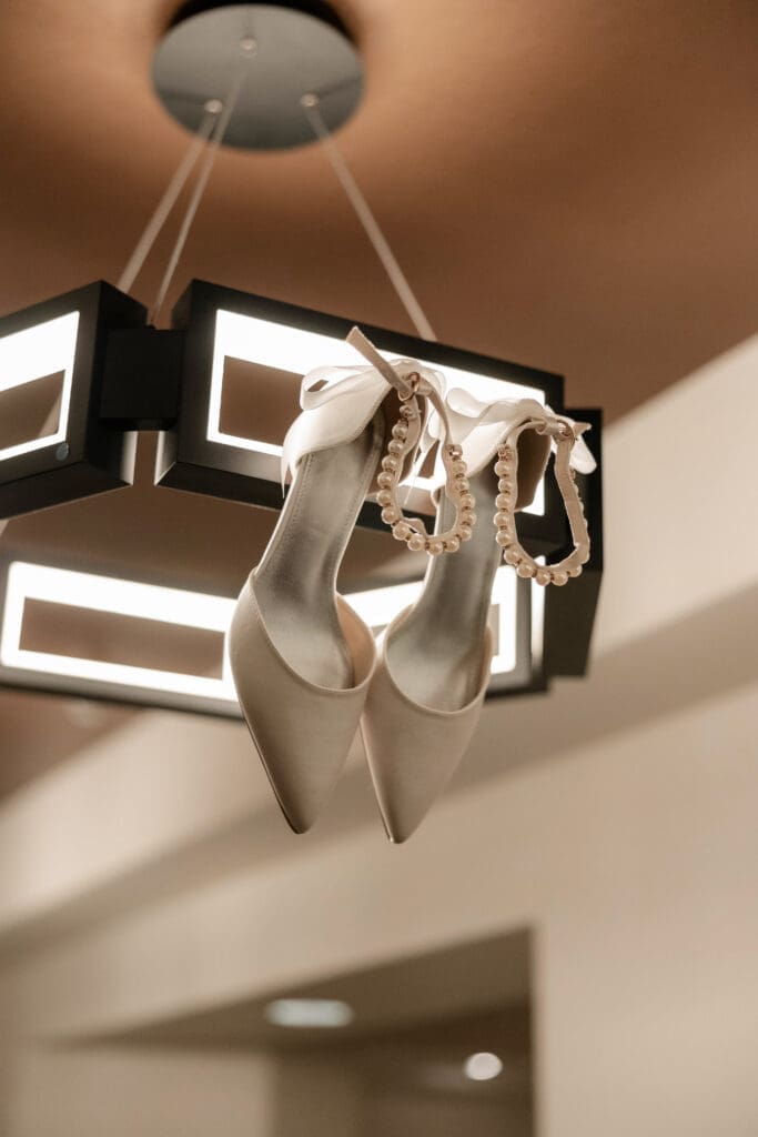 Bride's shoes hanging from chandelier