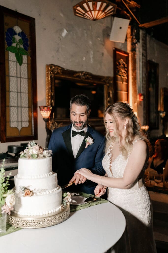 Bride and groom cutting the cake together