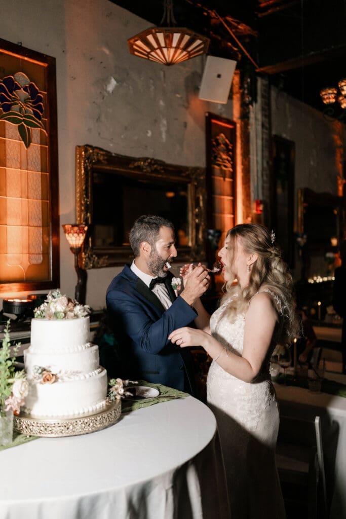 Bride and groom cutting the cake together