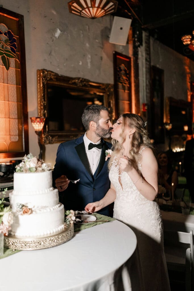 Bride and groom cutting the cake together