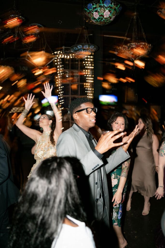 Wedding guests partying and dancing it up on the dancefloor at Nouveau Antique Art Bar in Houston, TX