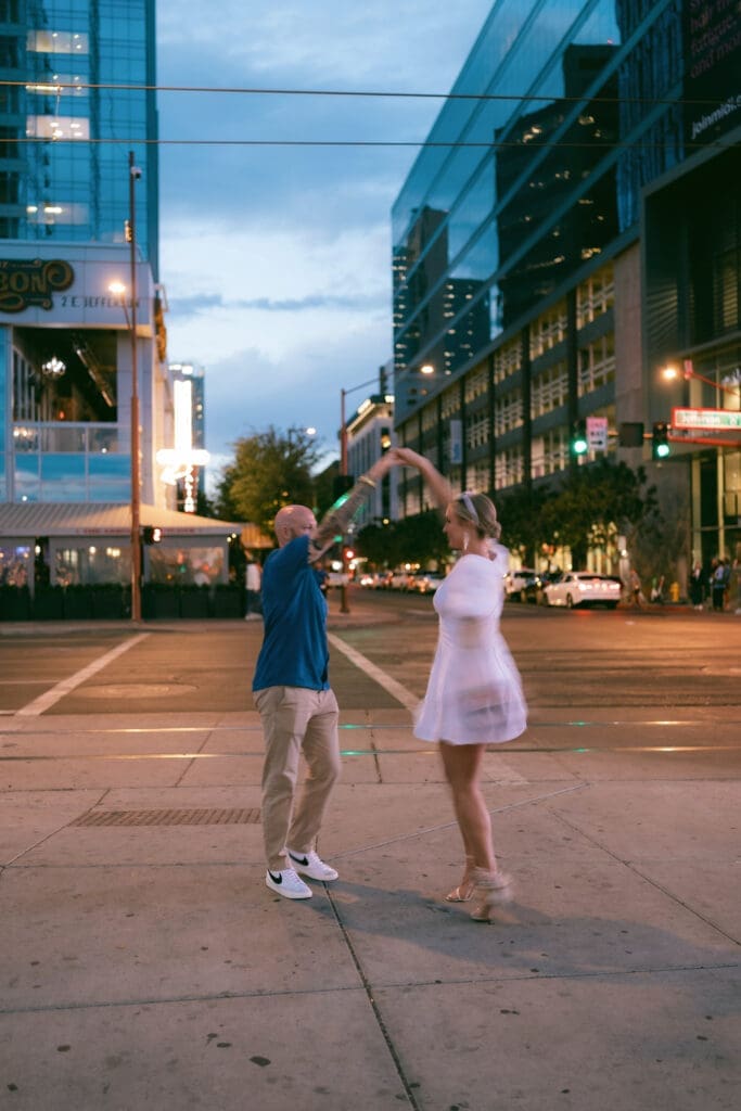 Photo of bride and groom dancing in front of the Arrogant Butcher in downtown Phoenix at blue hour