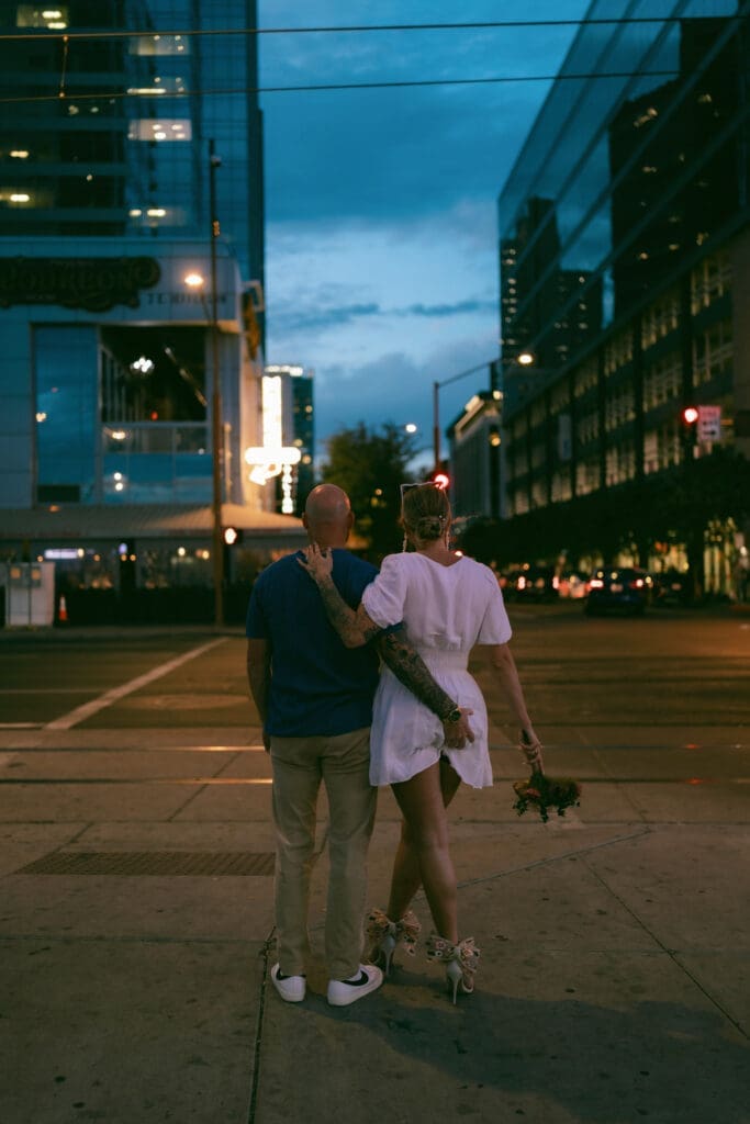 Photo of bride and groom kissing in front of the Arrogant Butcher in downtown Phoenix at blue hour