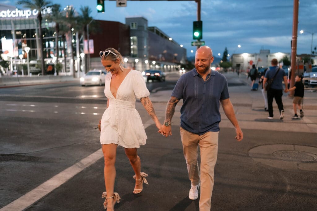 Photo of bride and groom walking across the street in downtown Phoenix at blue hour