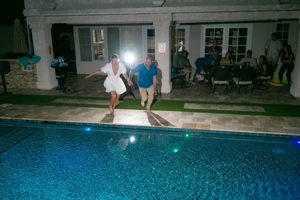 Bride and groom jumping into the pool at their Airbnb in Phoenix Arizona