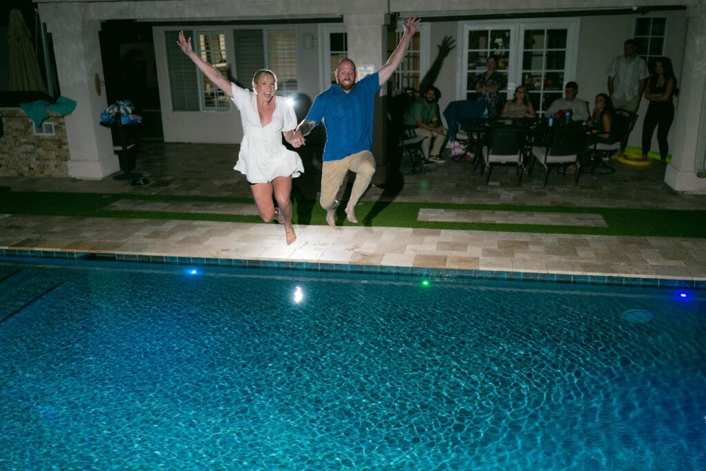Bride and groom jumping into the pool at their Airbnb in Phoenix Arizona