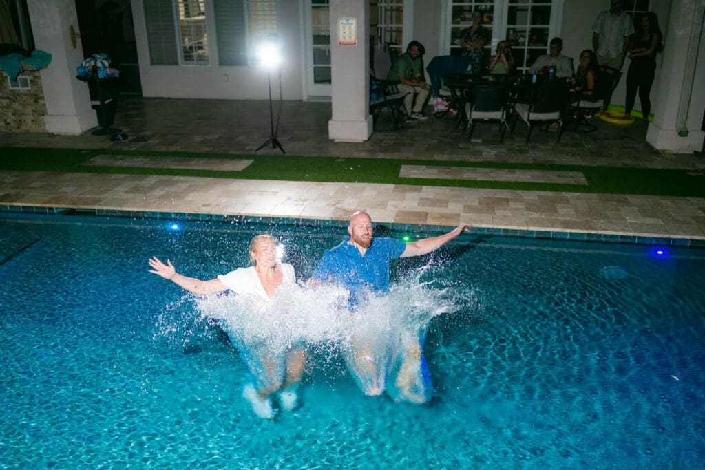 Bride and groom jumping into the pool at their Airbnb in Phoenix Arizona