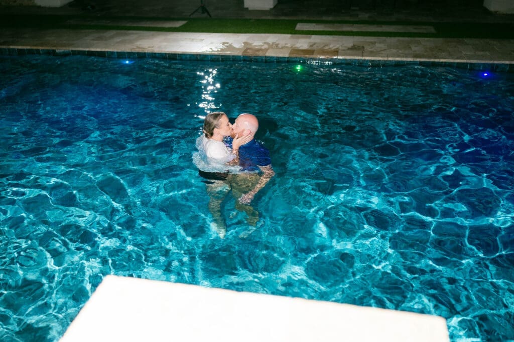 Bride and groom jumping into the pool at their Airbnb in Phoenix Arizona