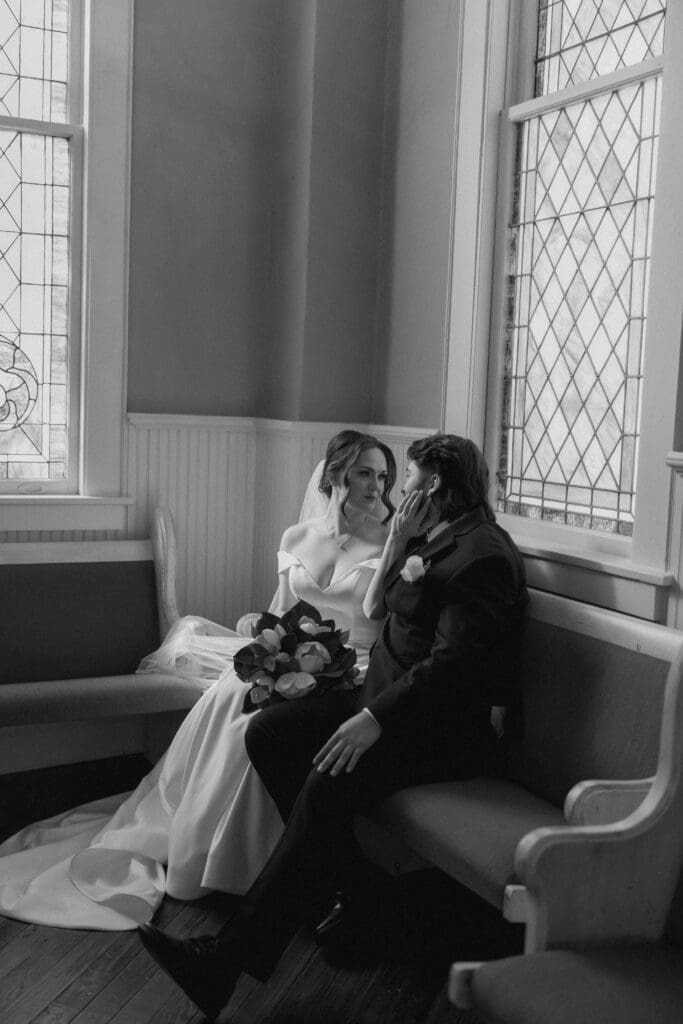 The 1906 wedding photographer taking photos of bride and groom in chapel against the stained glass windows