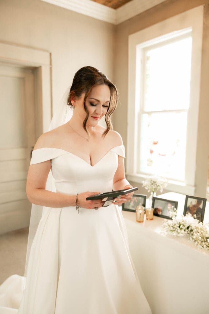 Bride tearing up at the Memorial table at The 1906 wedding venue in Whitesboro, TX