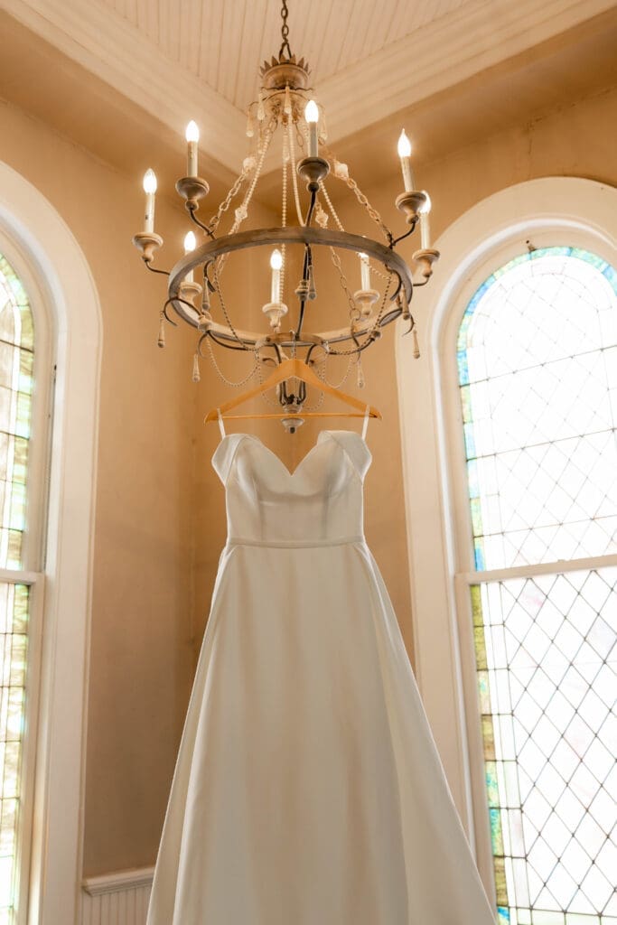 Dress hanging from chandelier photos at The 1906 wedding venue in Whitesboro, TX