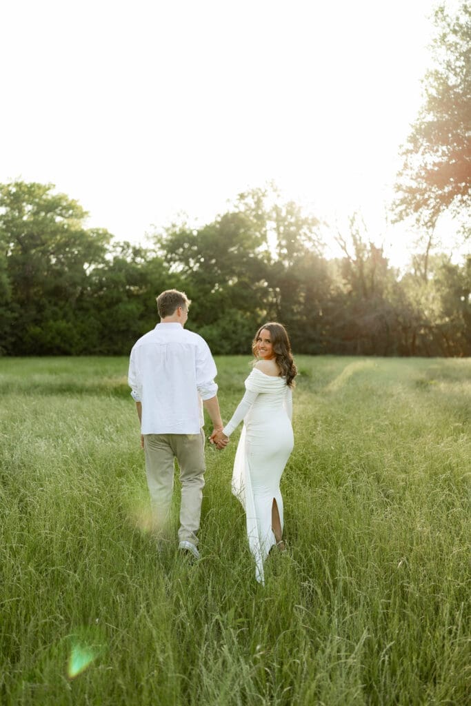 Couple posing in the grassy field during their golden hour Airfield Falls Maternity session