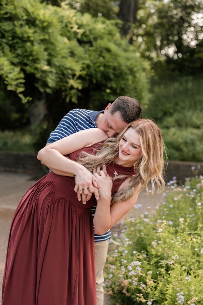 Man and woman cuddling in the Fort Worth Botanic Garden during their proposal engagement session in Fort Worth, TX