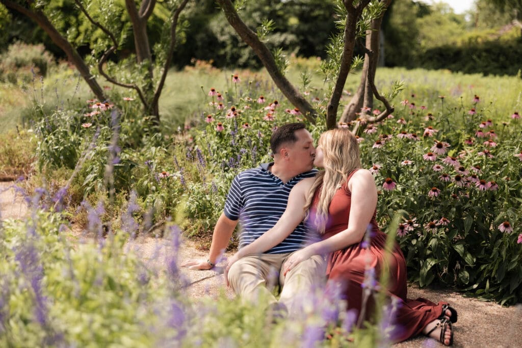 Man and woman kissing amongst the flowers