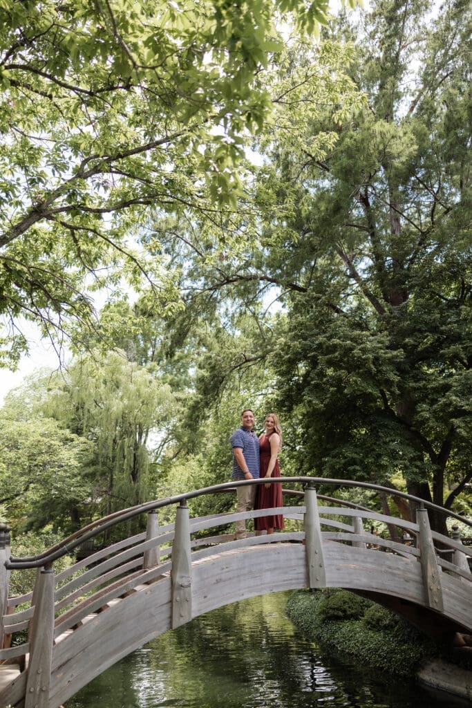 Man and woman embracing on the arched bridge in the Japanese Gardens at the Fort Worth Botanic Garden in Fort Worth, TX