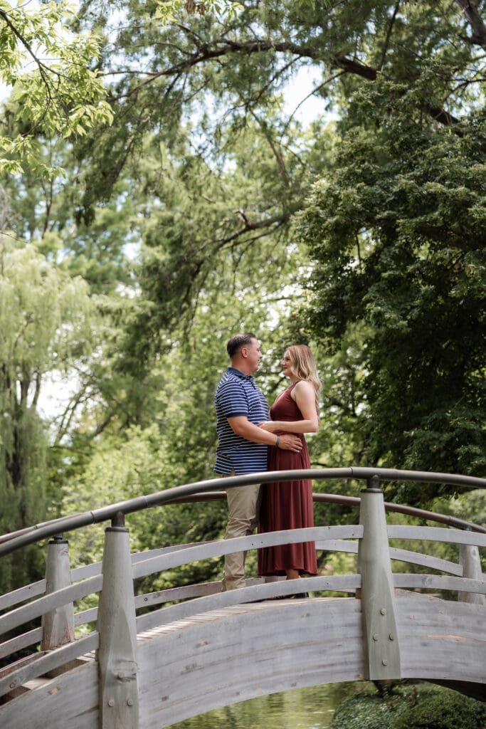 Man and woman embracing on the arched bridge in the Japanese Gardens at the Fort Worth Botanic Garden in Fort Worth, TX