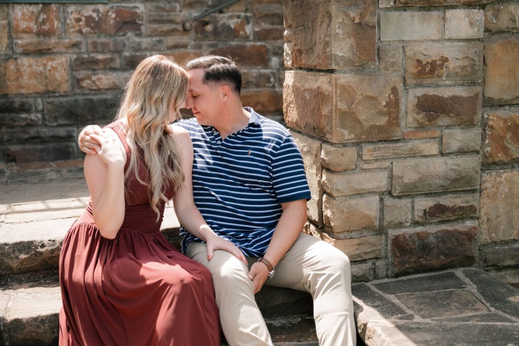 Man and woman cuddling in the Fort Worth Botanic Garden during their proposal engagement session in Fort Worth, TX