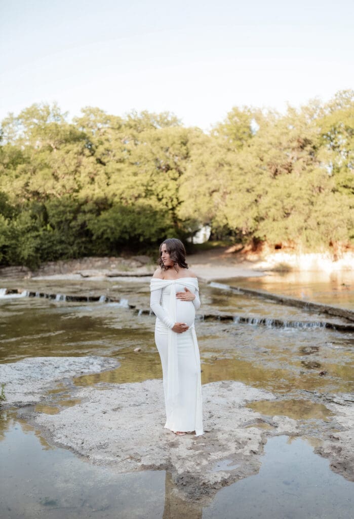 Woman posing in the creek during her golden hour Airfield Falls Maternity session