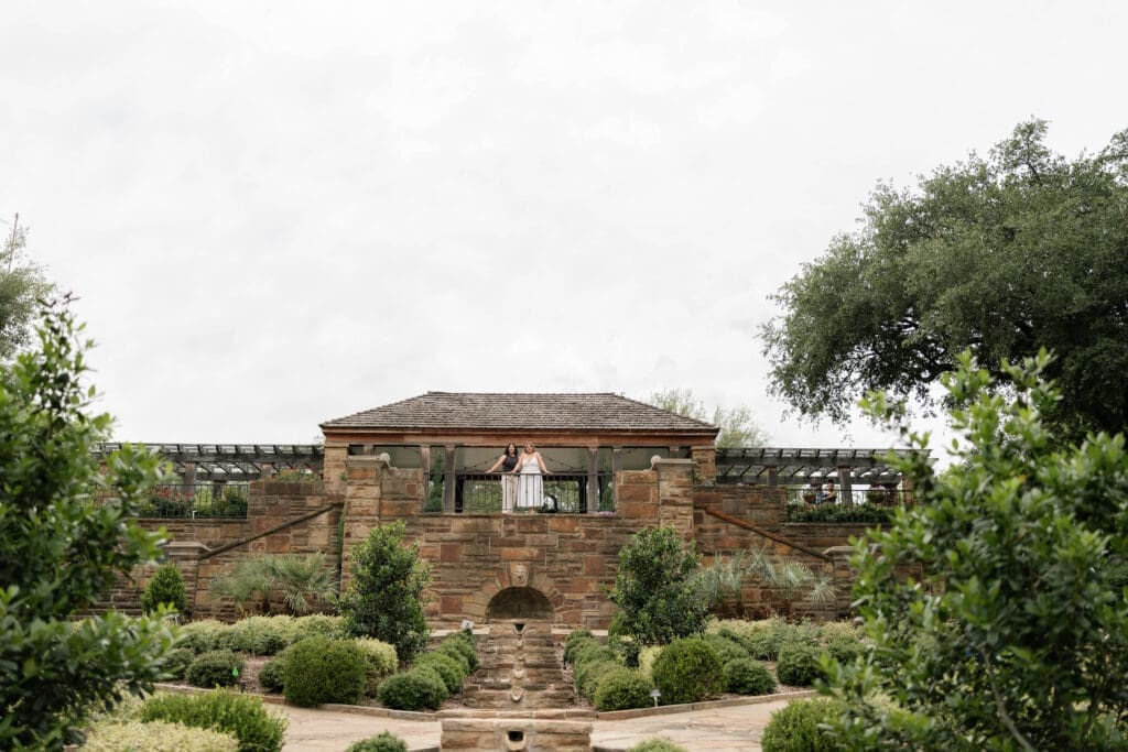 Two women looking out into the distance during their Fort Worth engagement session at the Fort Worth Botanic Garden