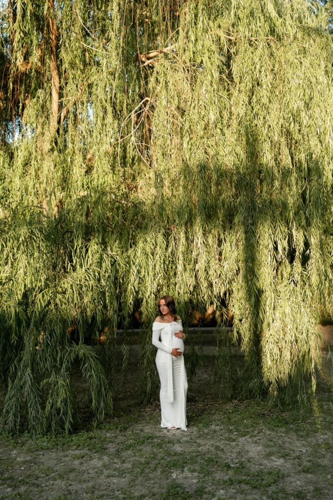 Woman posing in front of the willow tree at Airfield Falls Park during her photography session