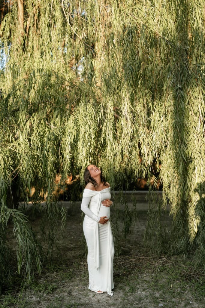 Woman posing in front of the willow tree at Airfield Falls Park during her photography session