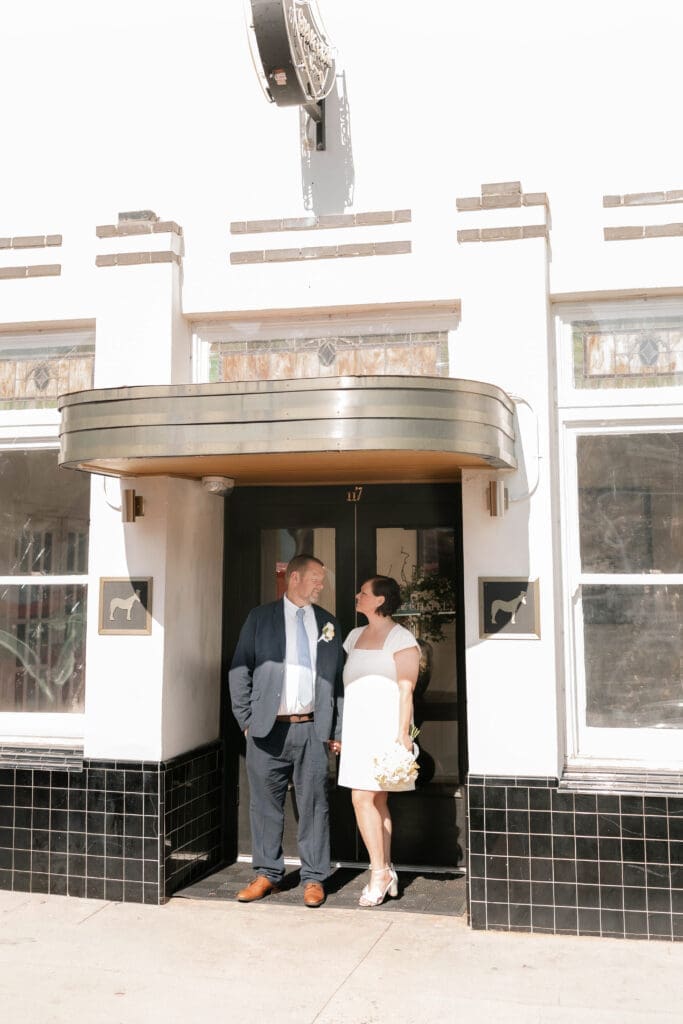 Bride and groom posing for portraits in front of the Jazz Chapel in downtown Weatherford TX