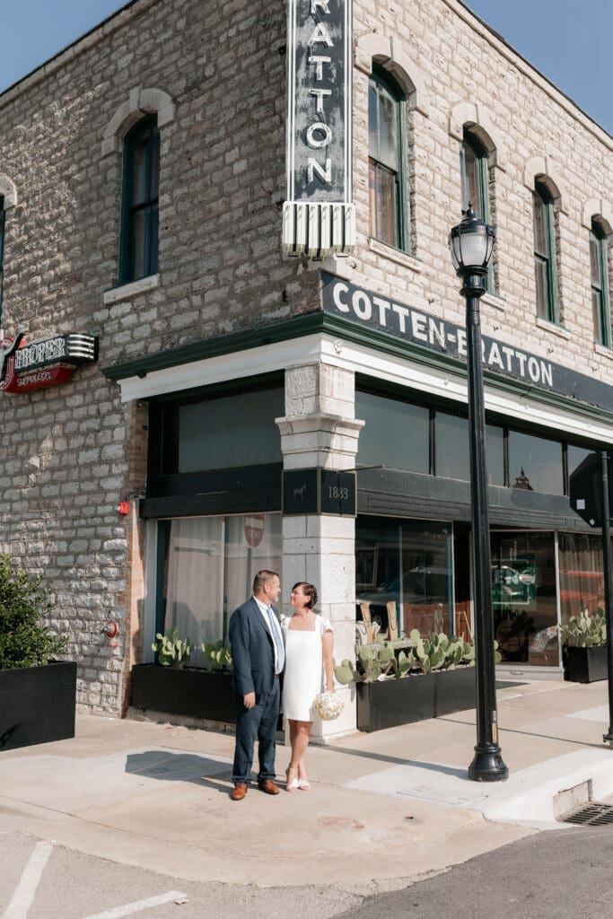 Bride and groom posing for portraits in front of the Jazz Chapel in downtown Weatherford TX