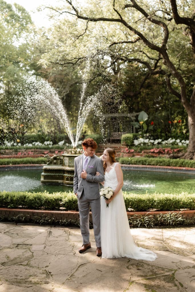 Bride and groom in front of fountain at Chandor Gardens in Weatherford, TX, during their wedding photography session