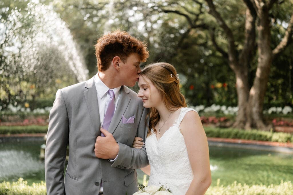Bride and groom in front of fountain at Chandor Gardens in Weatherford, TX, during their wedding photography session