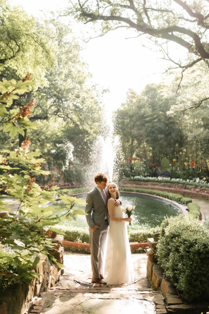Bride and groom in front of fountain at Chandor Gardens in Weatherford, TX, during their wedding photography session