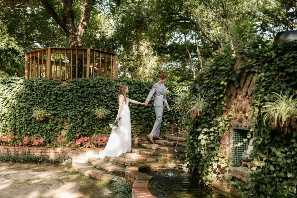 Groom leading bride up brick steps at Chandor Gardens in Weatherford, TX, during their wedding photography session