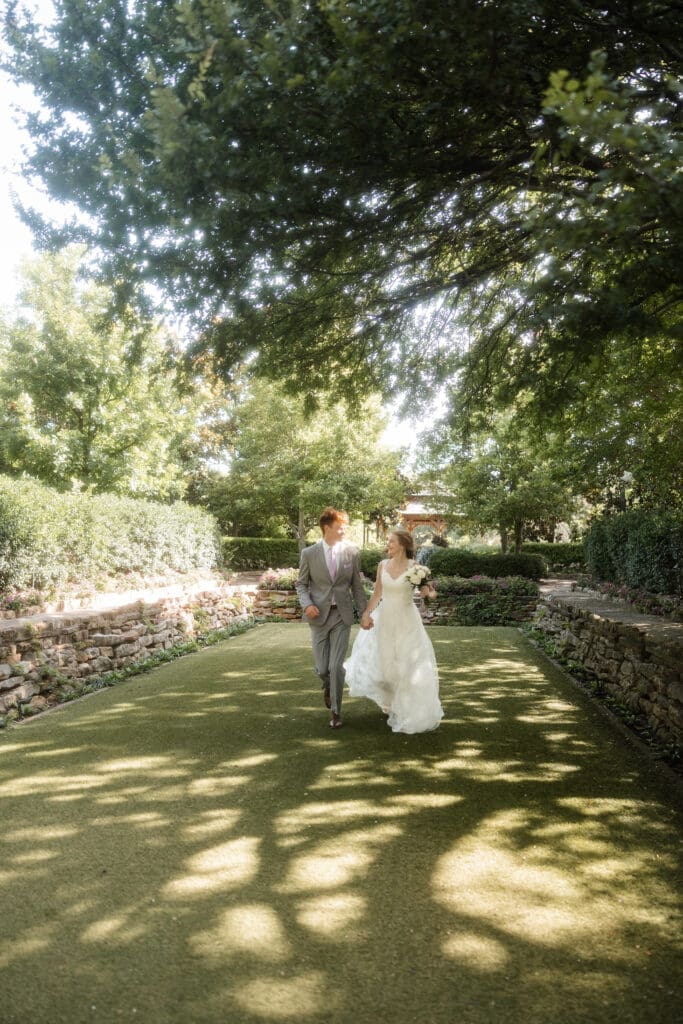 Bride and groom running across the lawn at Chandor Gardens in Weatherford, TX, during their wedding photography session