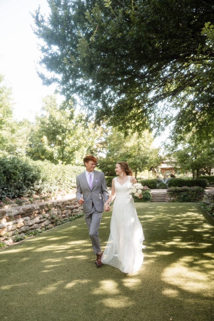 Bride and groom running across the lawn at Chandor Gardens in Weatherford, TX, during their wedding photography session